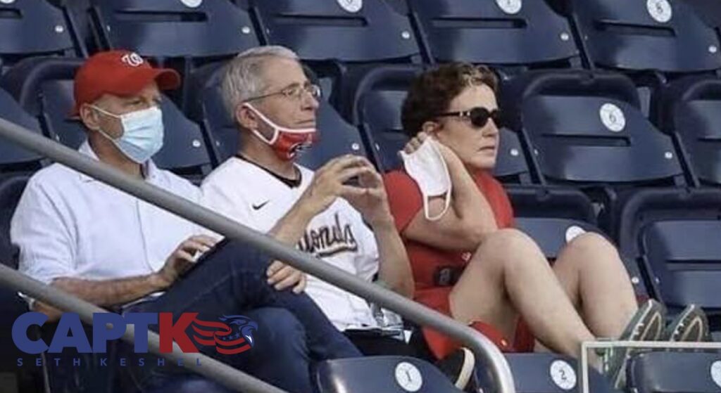 Dr. Anthony Fauci seated in the stands at Nationals Park with his mask pulled down, July 2020
