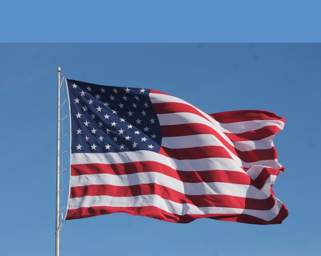 The American flag waving against a blue sky