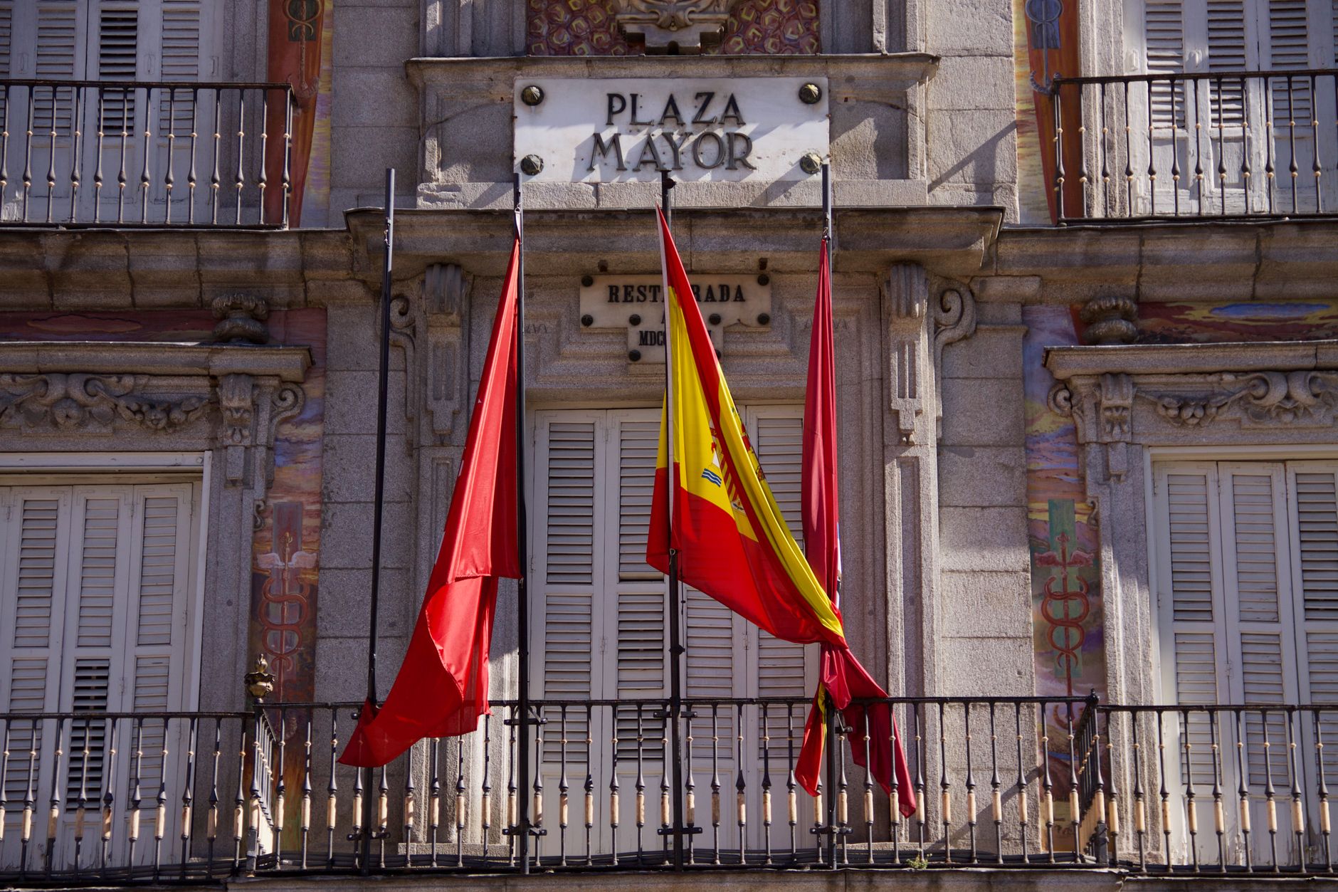 Facade of the Plaza Mayor in Madrid, Spain, with flags
