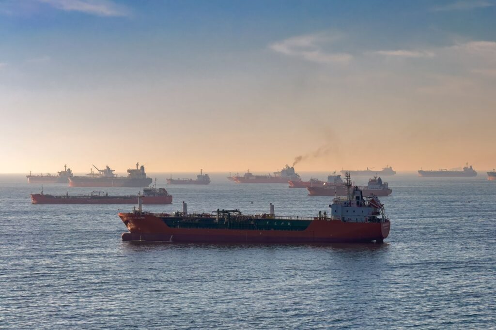 Cargo ships and oil tankers transiting a strait, capturing global trade and maritime logistics