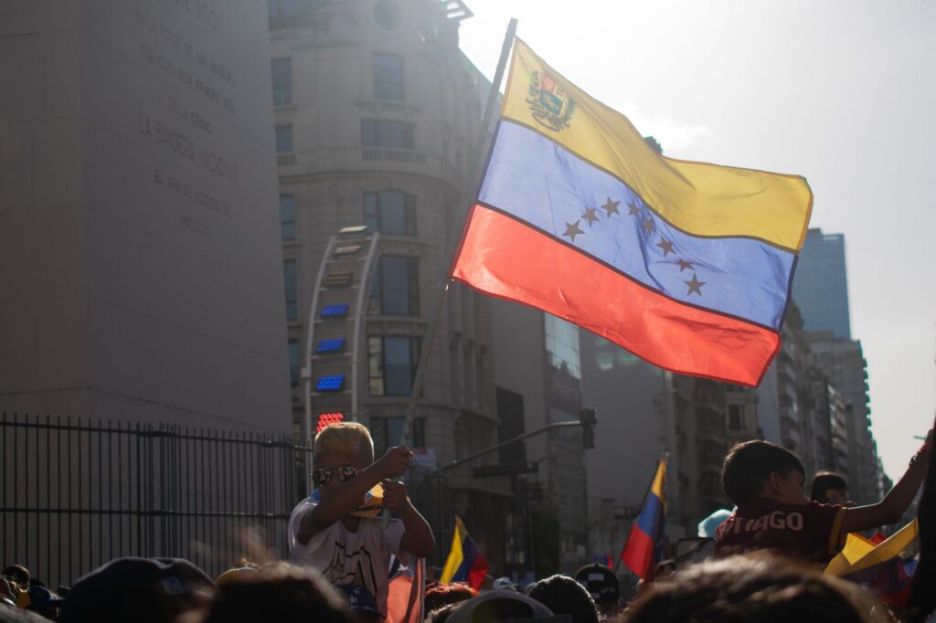 Venezuelans gather waving the national flag in a city protest for freedom and change