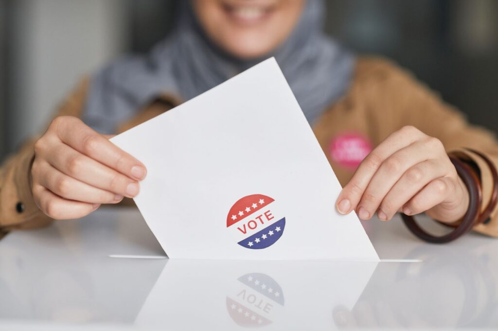 Close-up of hands holding a vote ballot, symbolizing election participation
