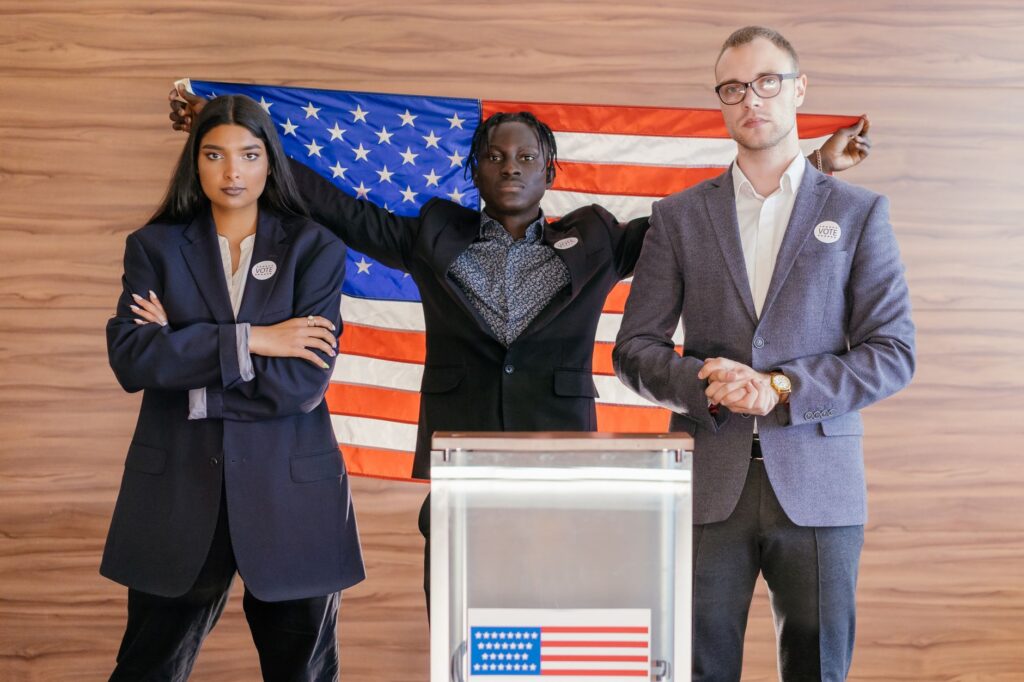 A group of diverse individuals standing in front of an American flag