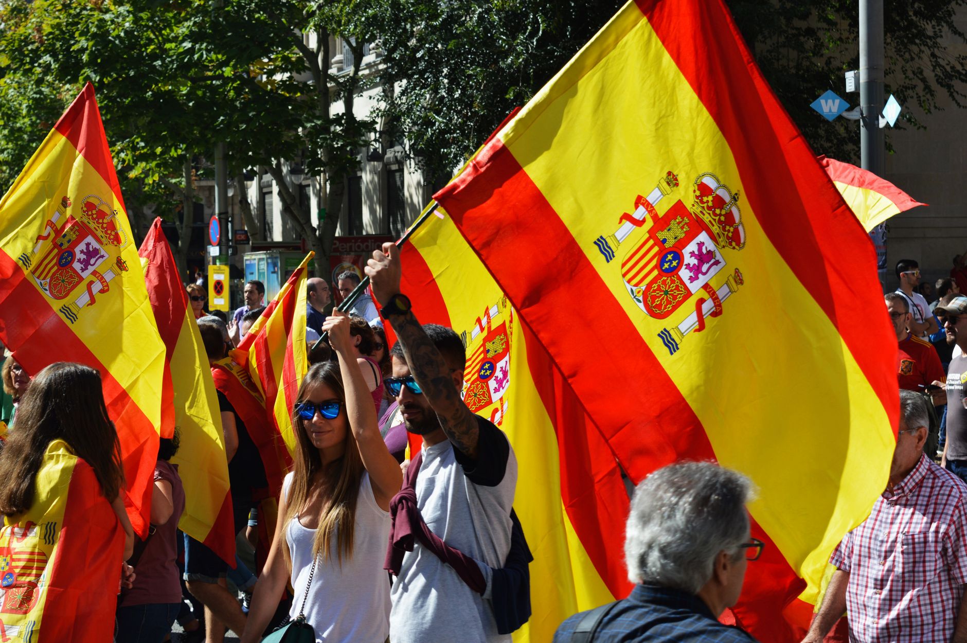 Crowd carrying Spanish flags at a street rally