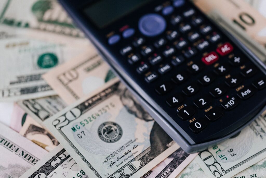 A calculator resting on a stack of US dollar bills