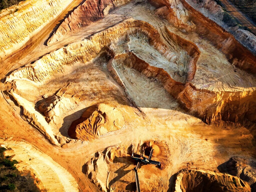 Aerial view of a terraced open-pit mine, illustrating critical minerals extraction