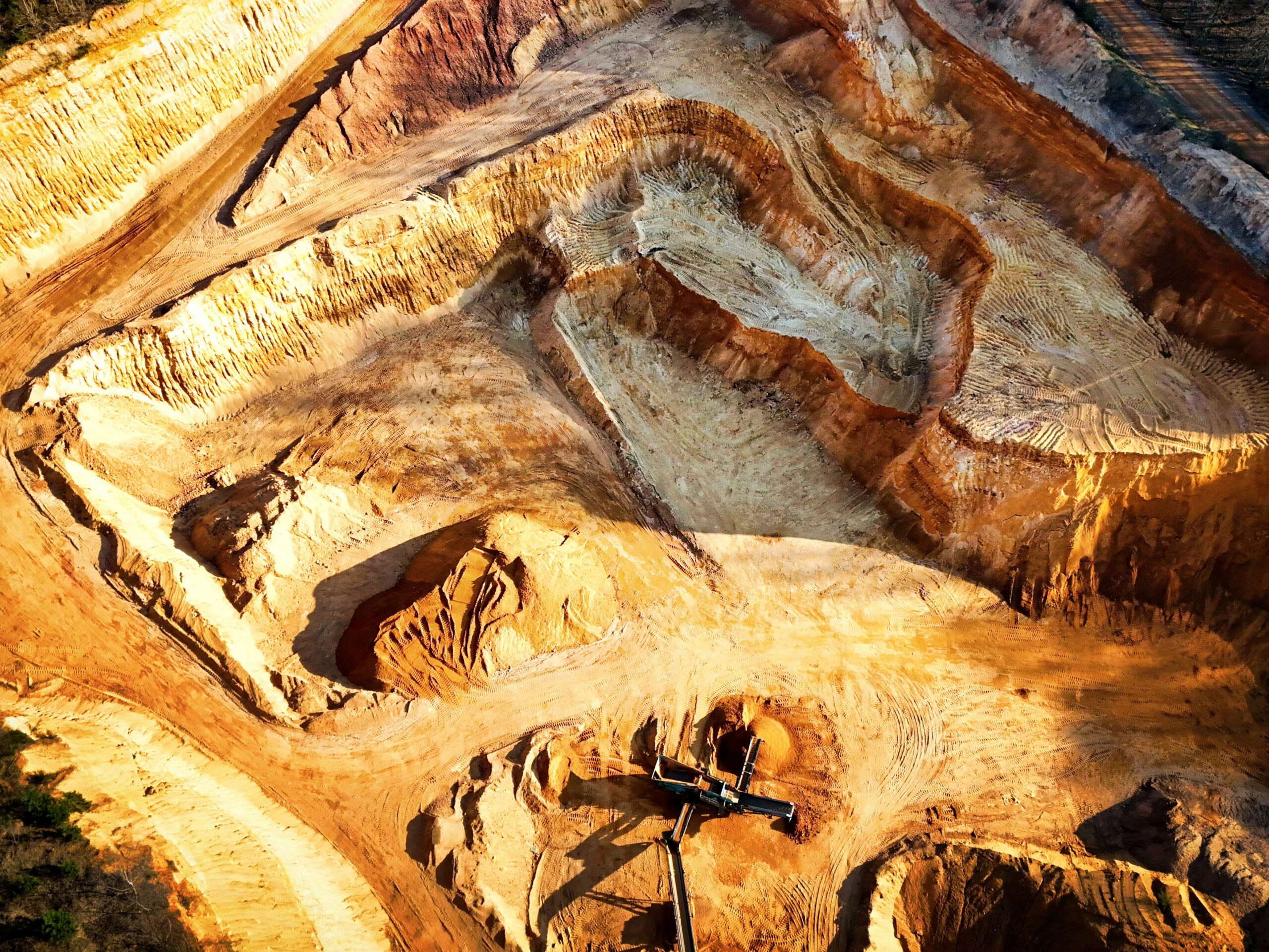 Aerial view of a terraced open-pit mine, illustrating critical minerals extraction