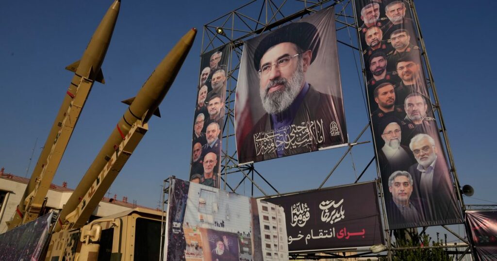 Iranian missiles on display in Tehran beneath banners with portraits of Iran's leaders